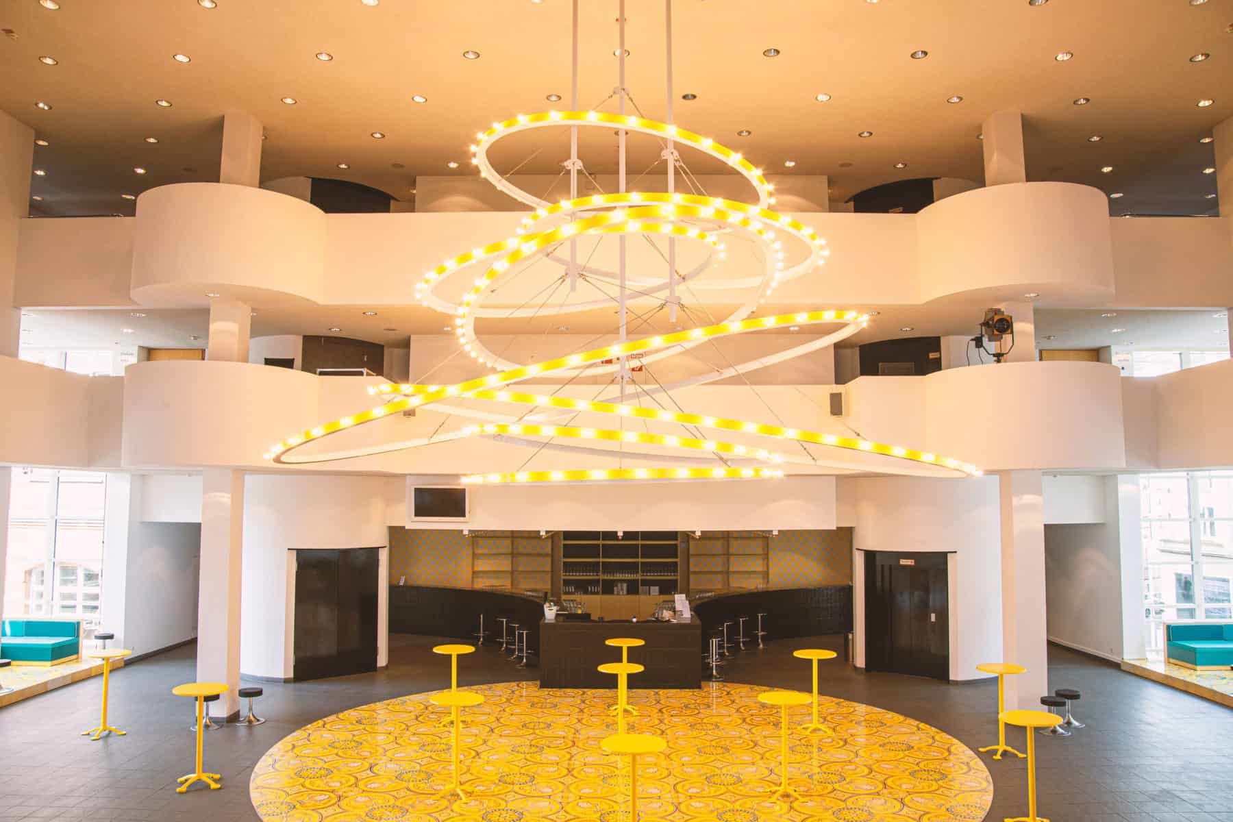 Zu sehen ist der Speisebereich des Staatstheaters Hannover. Der Raum ist menschenleer.Der Raum wird von einer großen, spiralförmigen Lampe ausgeleuchtet.